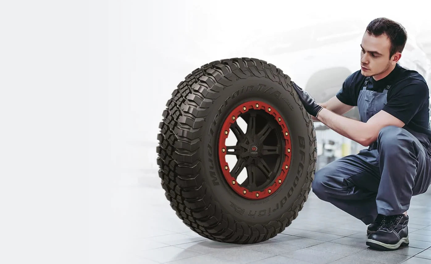 Mechanic inspecting an off-road tire.